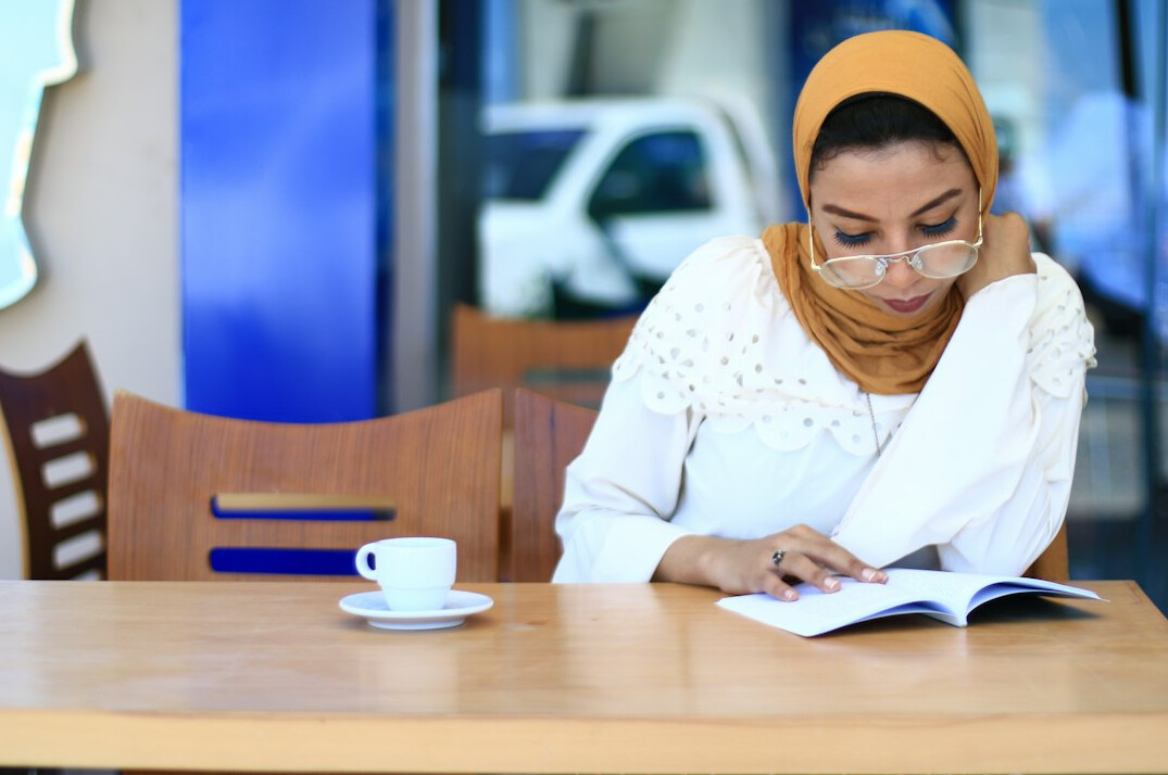 Malaysian compliance reviewer reading printed documents